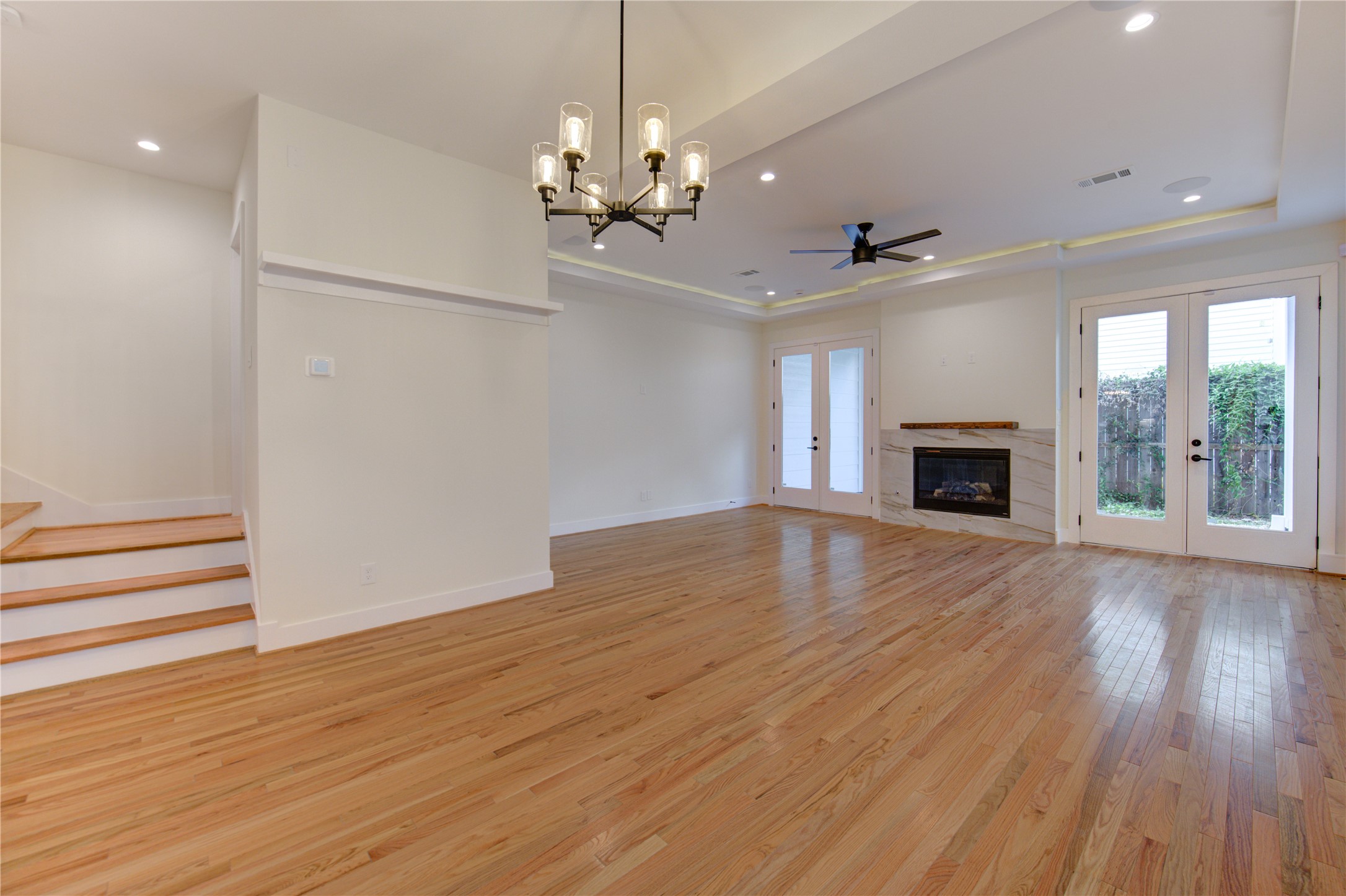 1810 Hazard Street, Unit A Houston, TX 77019 - Photo 37 of 47 an empty room with wooden floor fireplace and chandelier