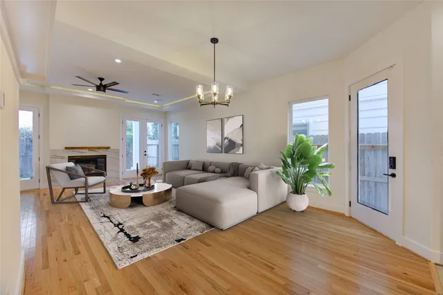 a living room with furniture hard wood floor and a chandelier