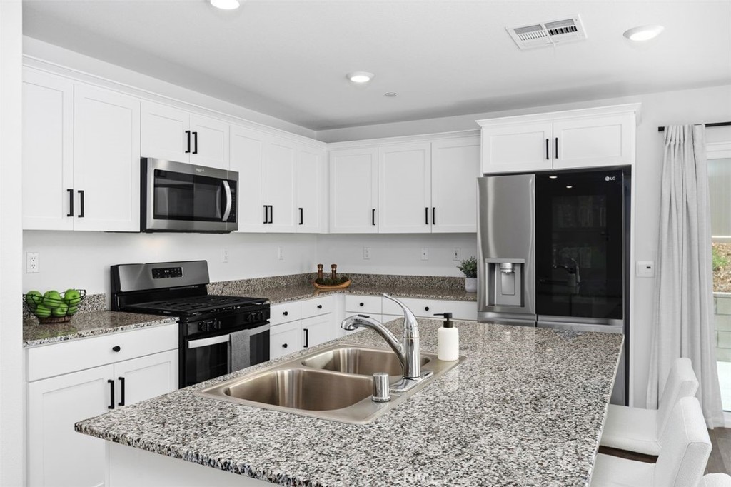 28876 Camaro Drive Winchester, CA 92596 - Photo 12 of 44 a kitchen with a sink stove and refrigerator