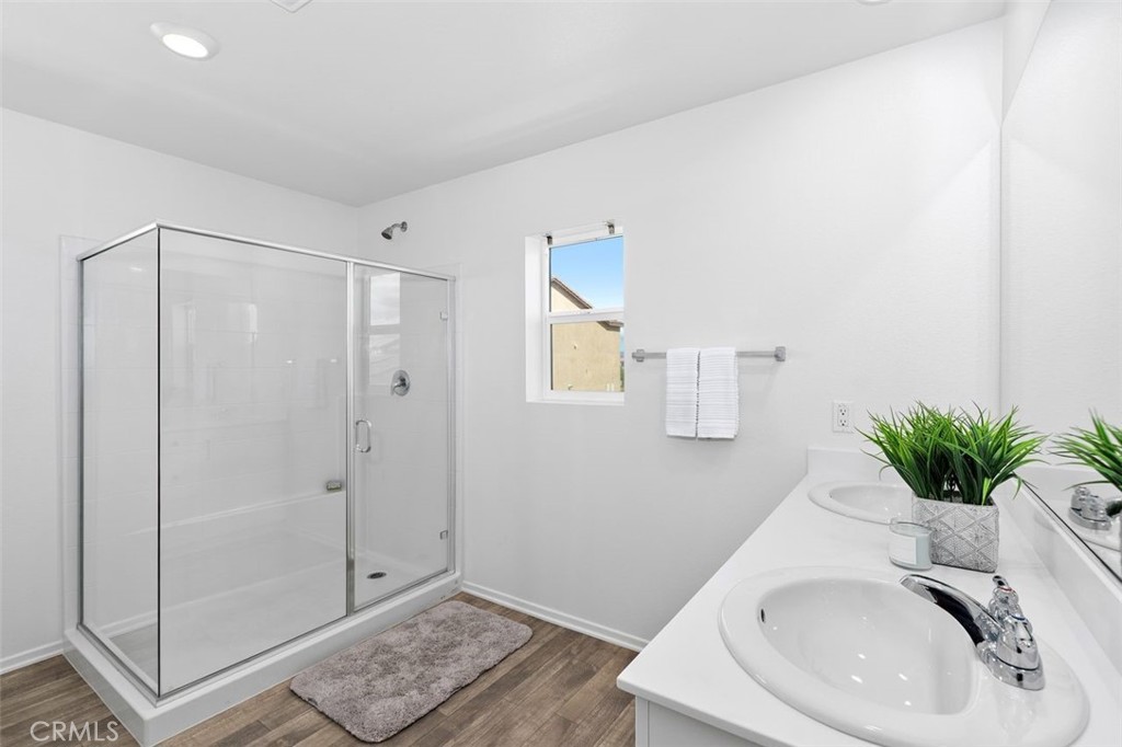 28876 Camaro Drive Winchester, CA 92596 - Photo 19 of 44 a bathroom with a sink a glass door a shower and a mirror