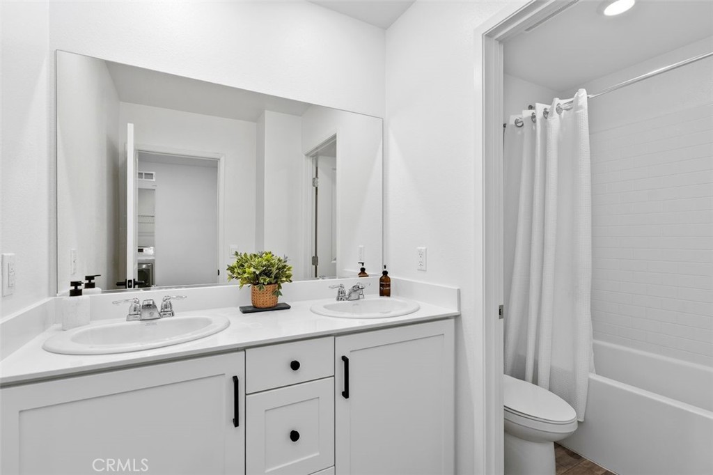 28876 Camaro Drive Winchester, CA 92596 - Photo 29 of 44 a bathroom with a double vanity sink toilet and a mirror