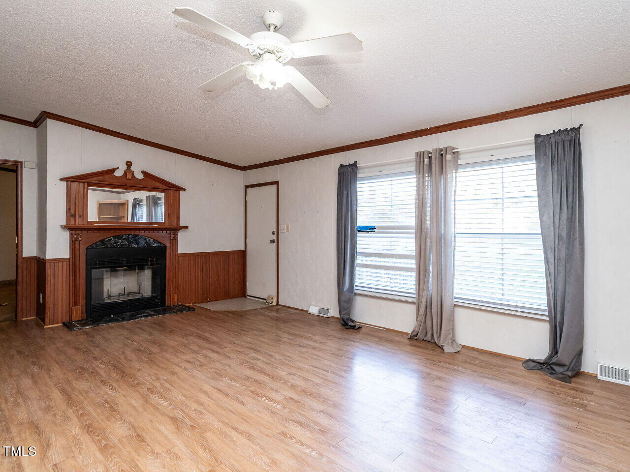 9140 Ransdell Road Raleigh, NC 27603 - Photo 7 of 26 an empty room with windows fireplace and a ceiling fan