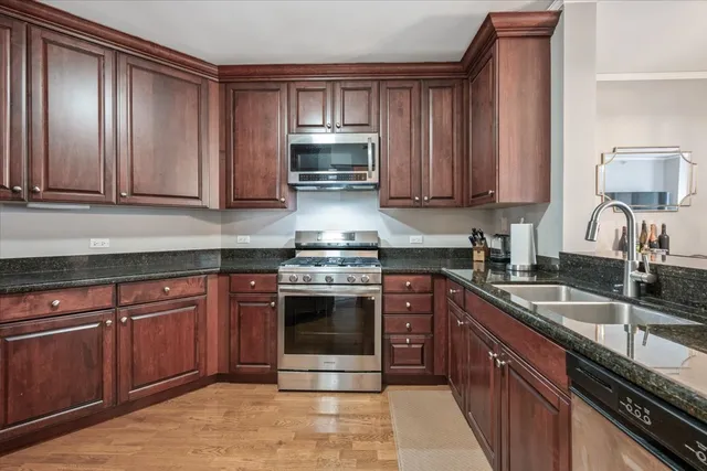 a kitchen with granite countertop wooden cabinets stainless steel appliances and a counter space