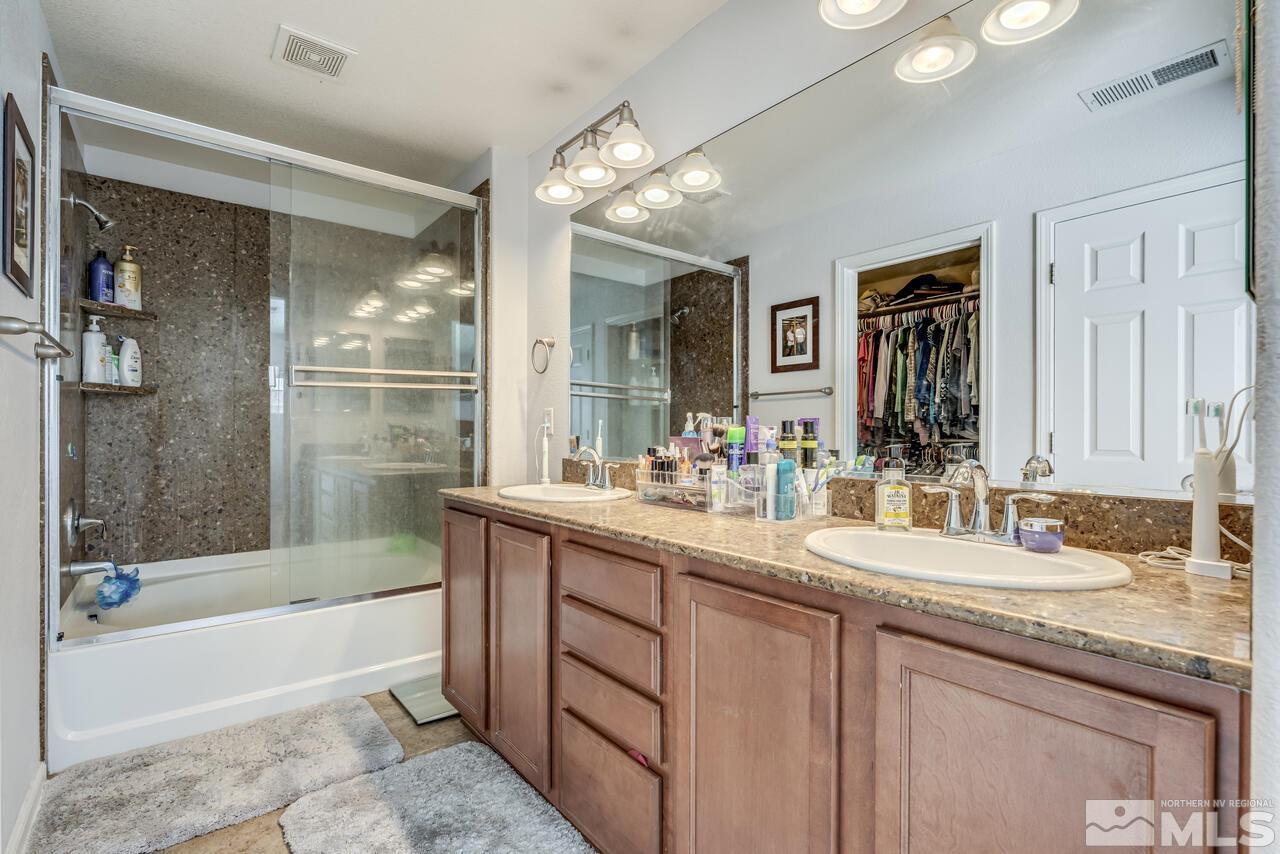 8950 Yeager Street Reno, NV 89506 - Photo 23 of 40 a bathroom with a granite countertop sink mirror and bathtub