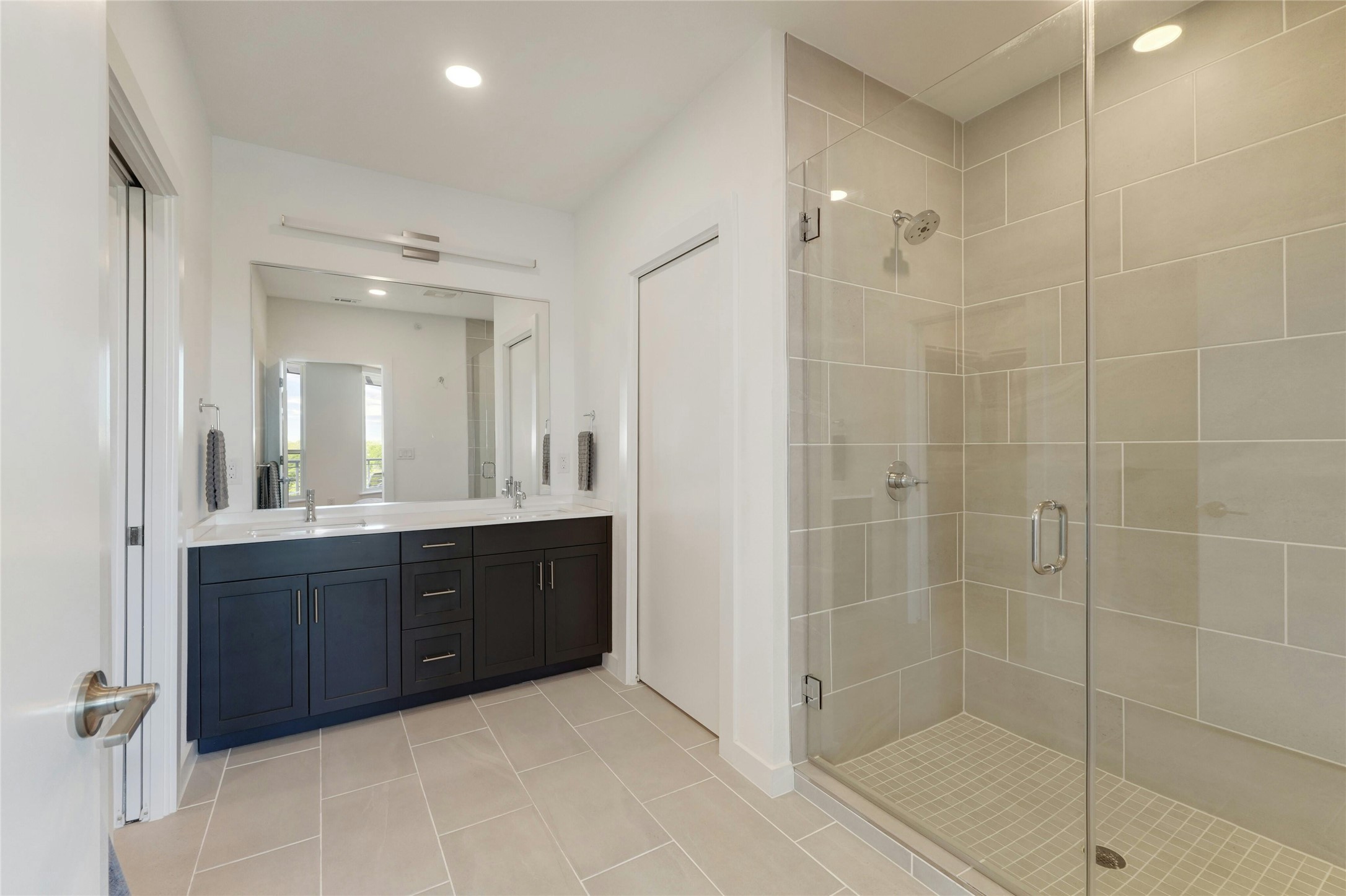 1600 South 1st Street, Unit 403 Austin, TX 78704 - Photo 16 of 33 a bathroom with a glass door shower a sink and mirror