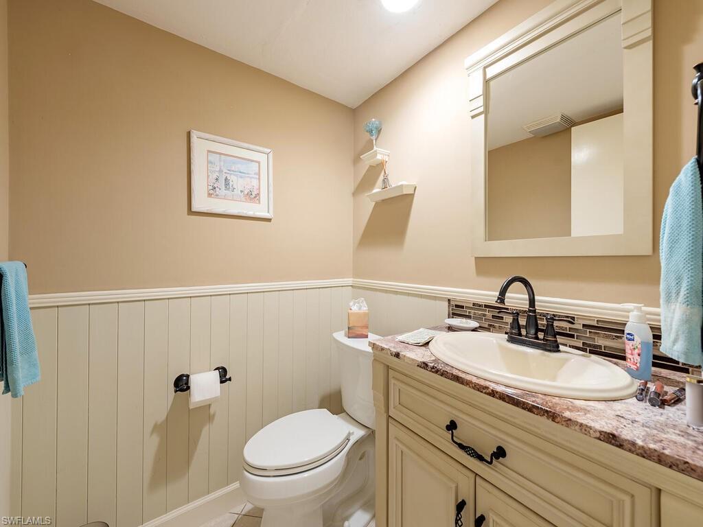 508 Bristle Cone Lane, Unit 55 Naples, FL 34113 - Photo 12 of 19 a bathroom with a granite countertop sink toilet and a mirror