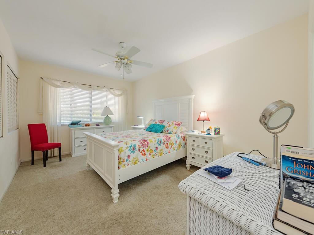 508 Bristle Cone Lane, Unit 55 Naples, FL 34113 - Photo 7 of 19 a bedroom with a bed and a chandelier