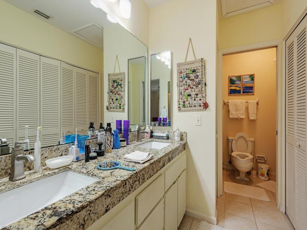 508 Bristle Cone Lane, Unit 55 Naples, FL 34113 - Photo 8 of 19 a bathroom with a granite countertop sink a toilet a mirror and shower