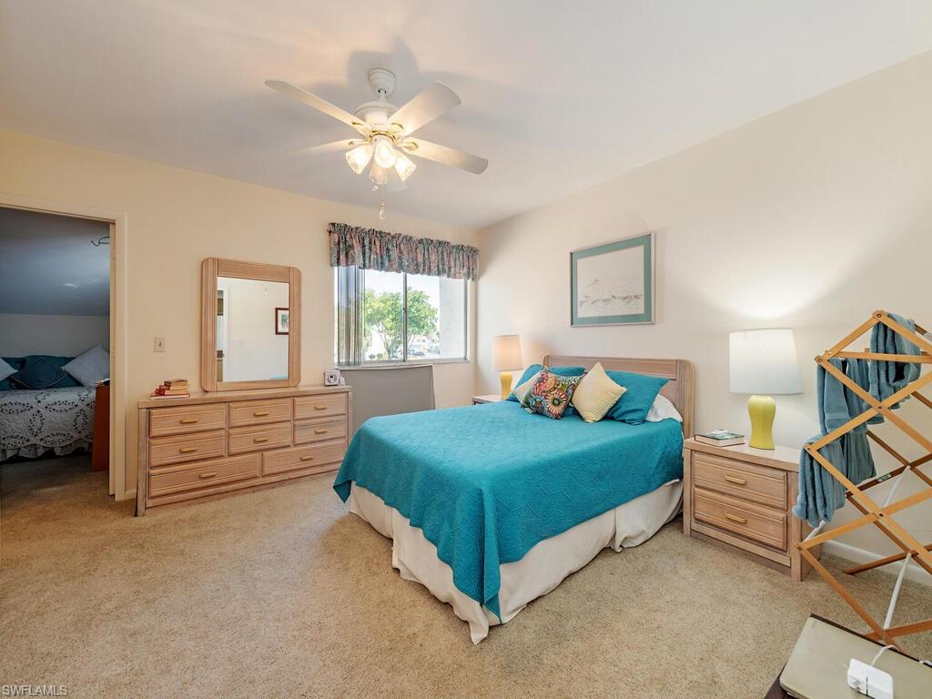 508 Bristle Cone Lane, Unit 55 Naples, FL 34113 - Photo 9 of 19 a bedroom with a bed and a chandelier