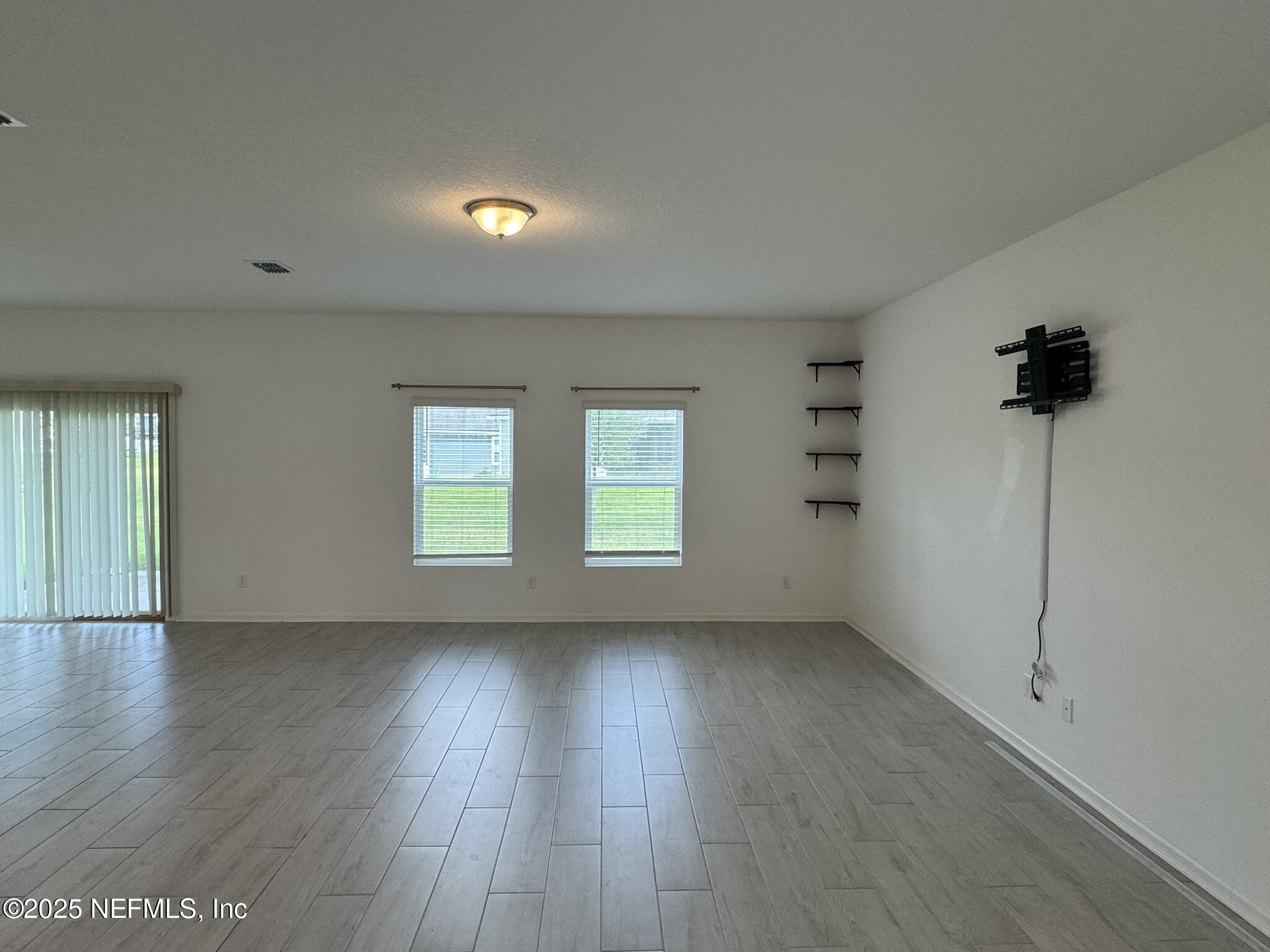 3145 Flower Branch Avenue Orange Park, FL 32073 - Photo 15 of 52 an empty room with wooden floor and windows