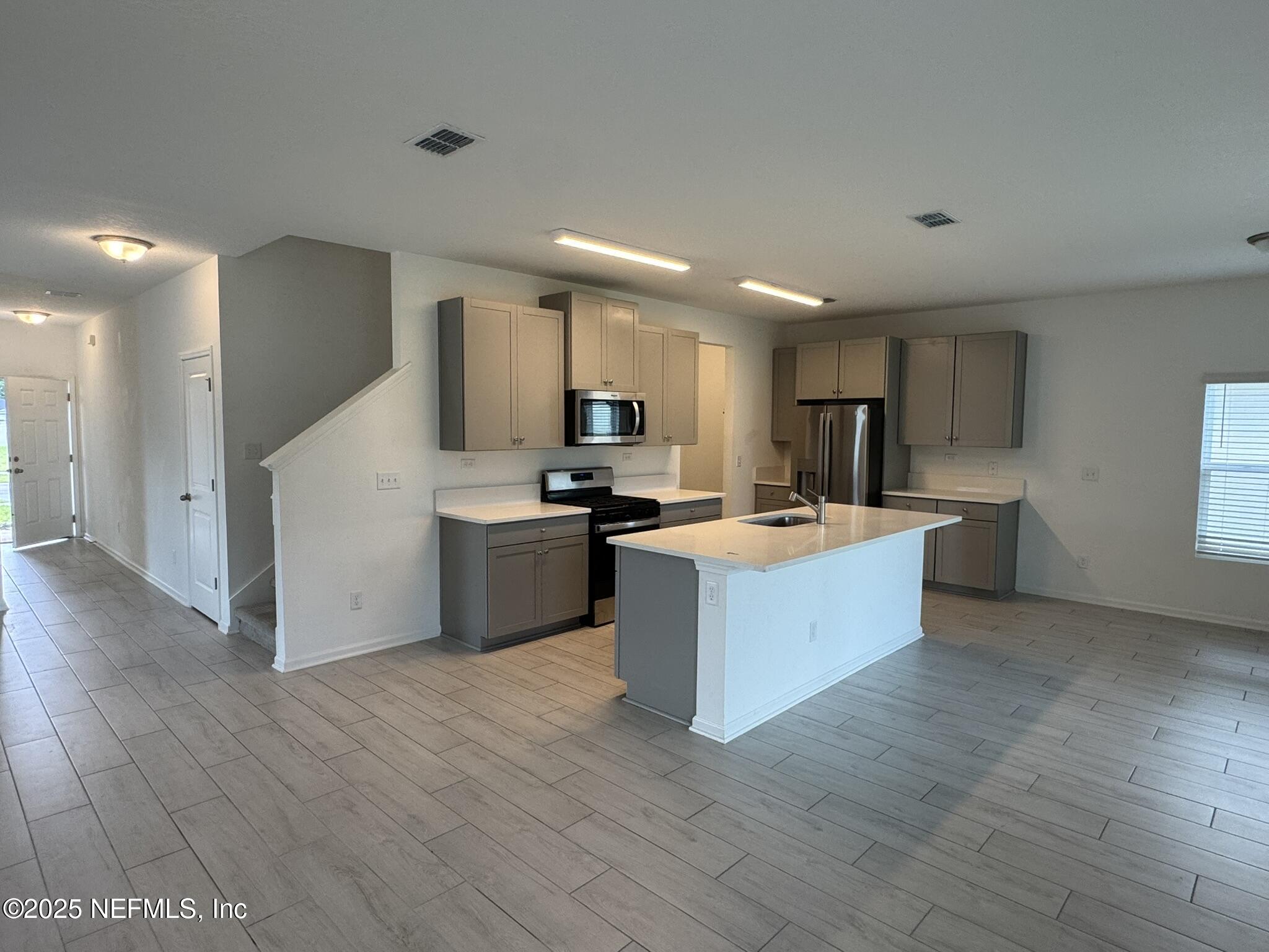 3145 Flower Branch Avenue Orange Park, FL 32073 - Photo 16 of 52 a large kitchen with stainless steel appliances kitchen island a large counter top and a wooden floors