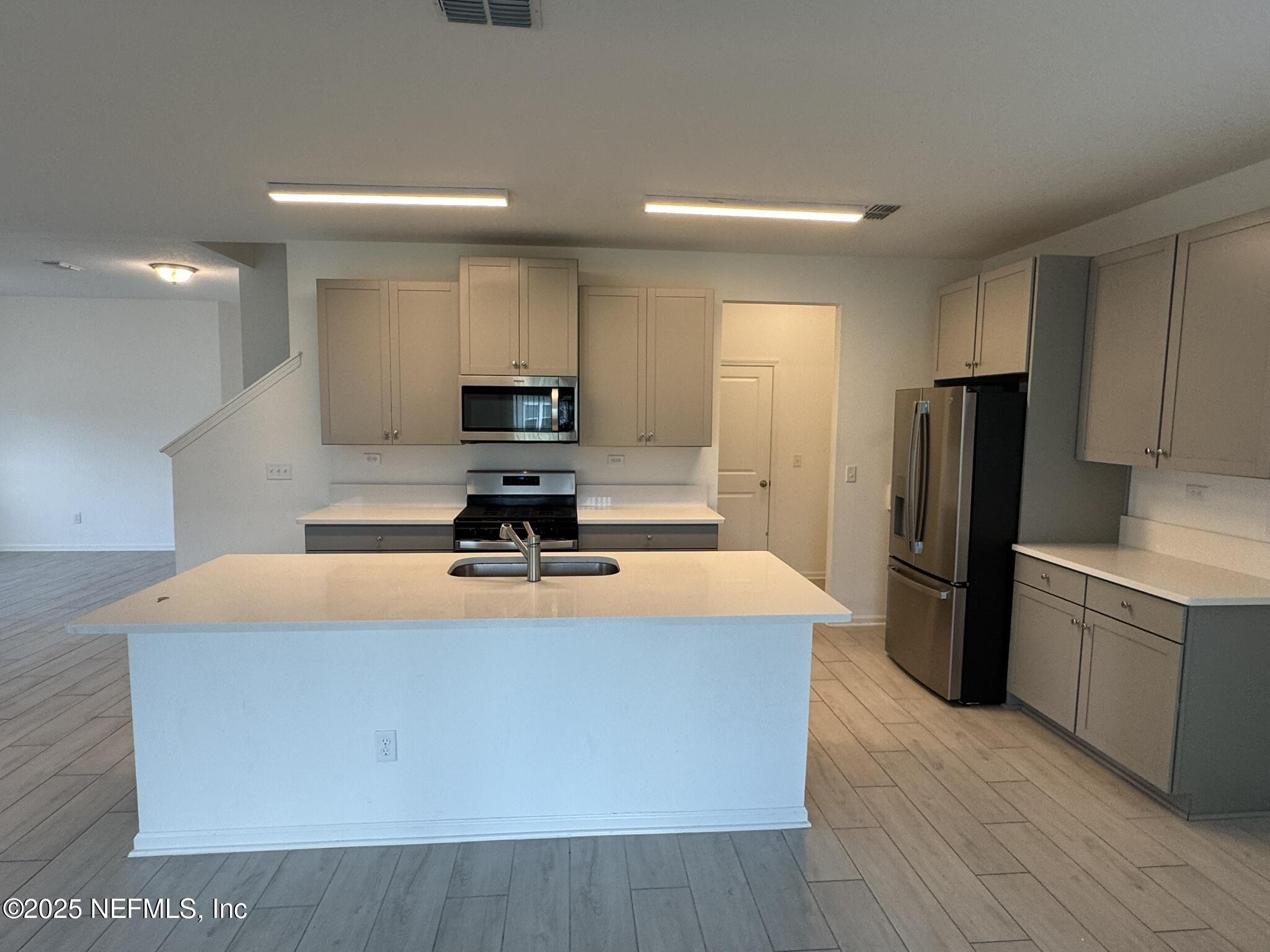 3145 Flower Branch Avenue Orange Park, FL 32073 - Photo 19 of 52 a kitchen with stainless steel appliances a refrigerator a sink a stove a microwave and wooden floor