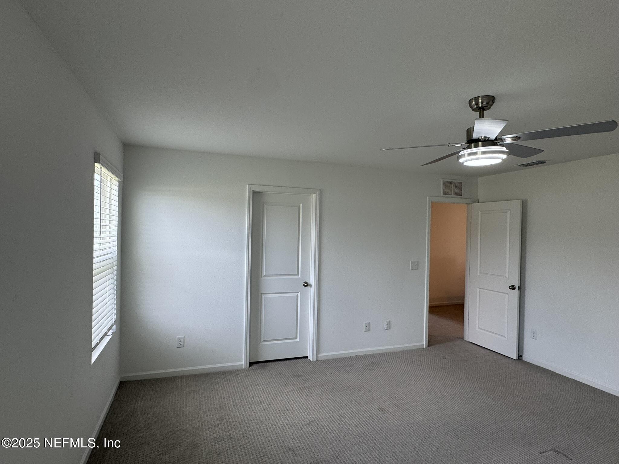 3145 Flower Branch Avenue Orange Park, FL 32073 - Photo 42 of 52 an empty room with a chandelier fan and windows