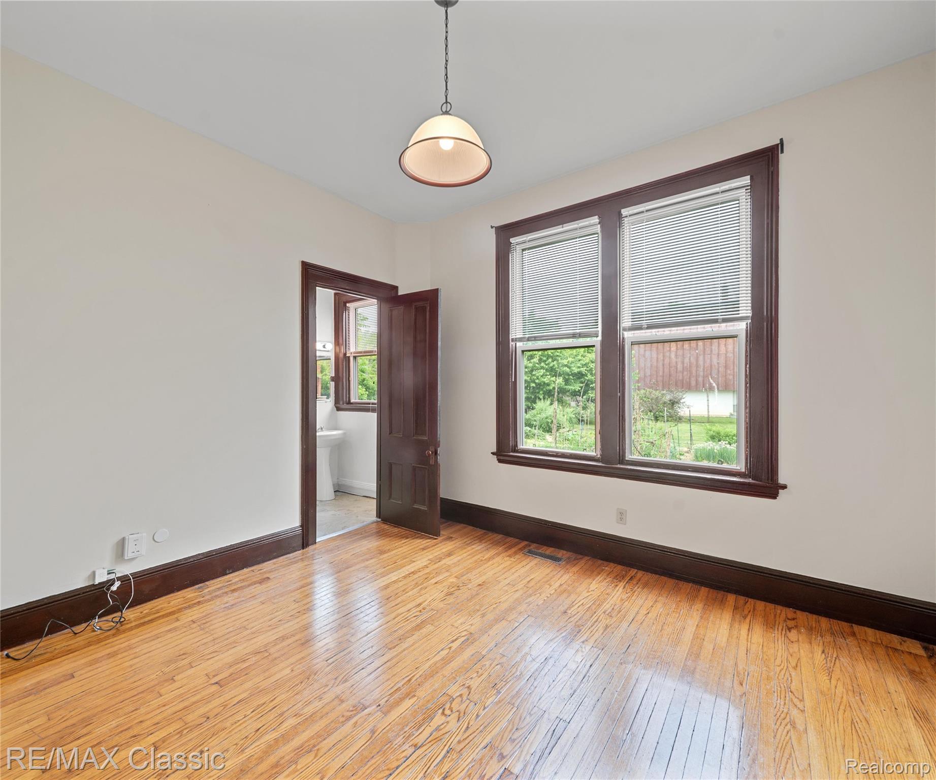 3941 Trumbull Detroit, MI 48208 - Photo 18 of 46 Hardwood flooring throughout the room, complemented by a suspended light fixture