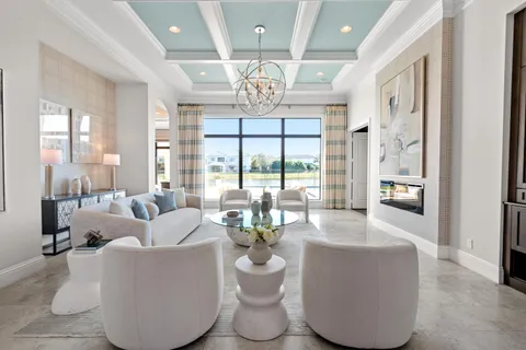 a dining room with furniture large windows a chandelier and wooden floor