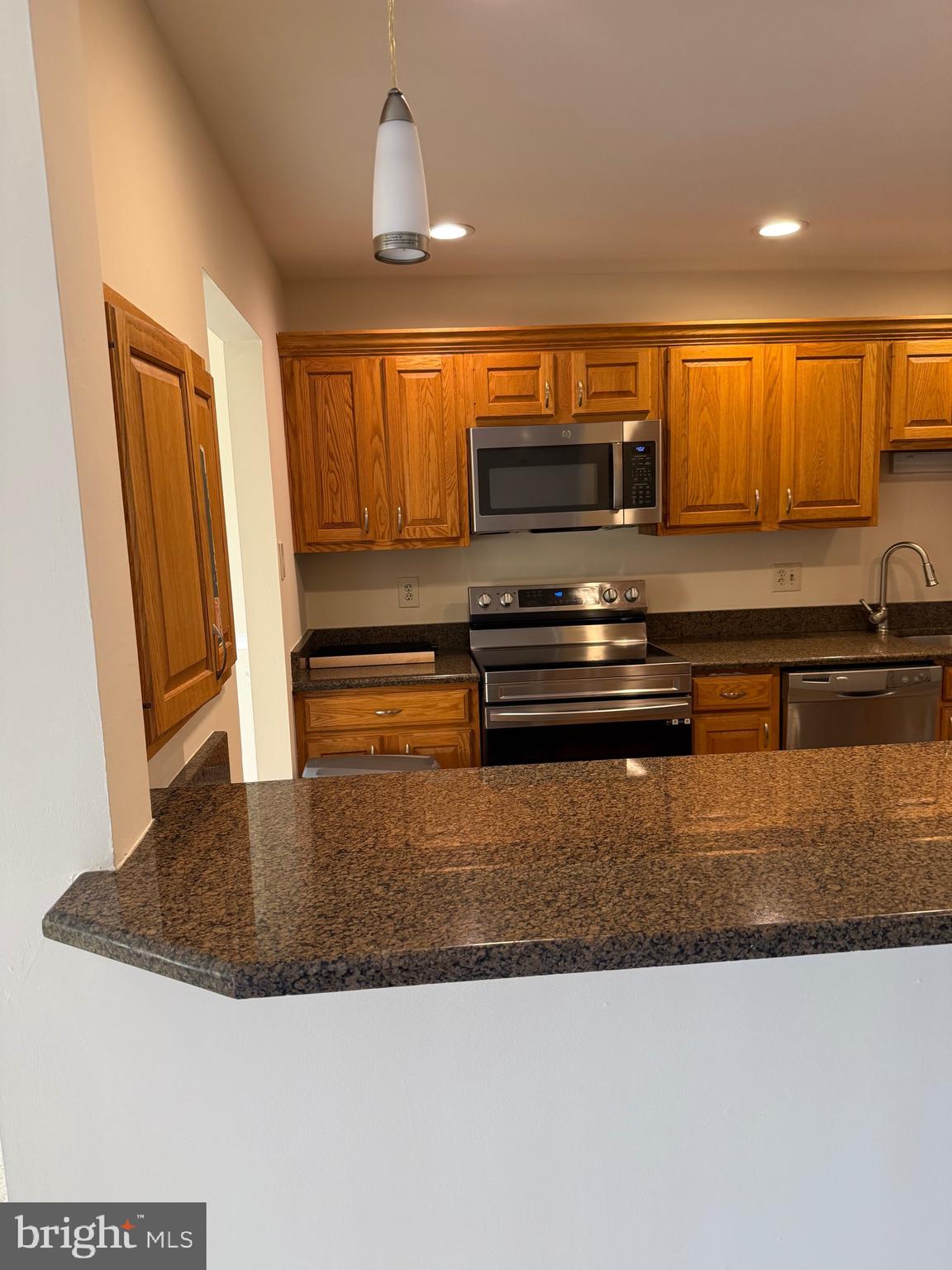 531 Florida Avenue, Unit 104 Herndon, VA 20170 - Photo 6 of 46 a kitchen with kitchen island granite countertop a stove a sink and a granite counter top