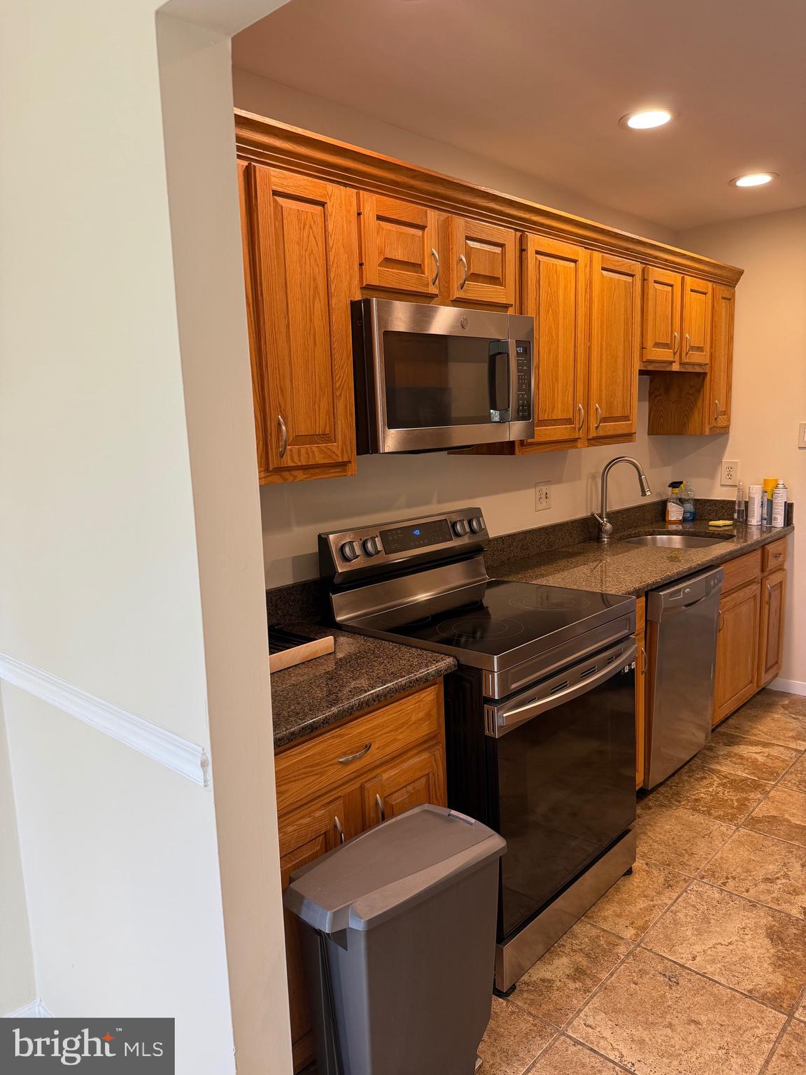 531 Florida Avenue, Unit 104 Herndon, VA 20170 - Photo 9 of 46 a kitchen with granite countertop a sink and a stove top oven