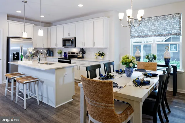 a kitchen with granite countertop kitchen island stainless steel appliances a dining table and chairs