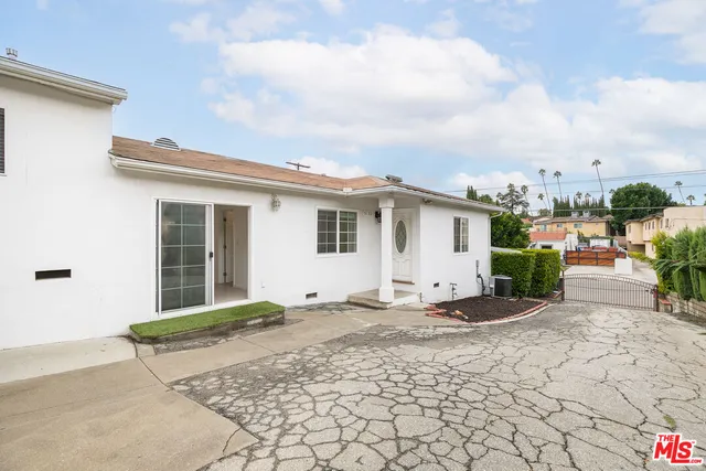 a view of a house with backyard and sitting area
