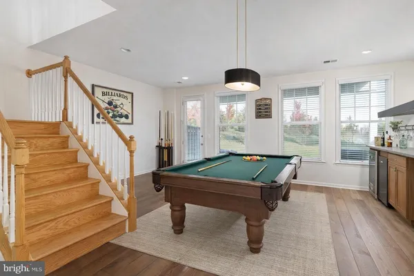 a room with pool tables and wooden floor