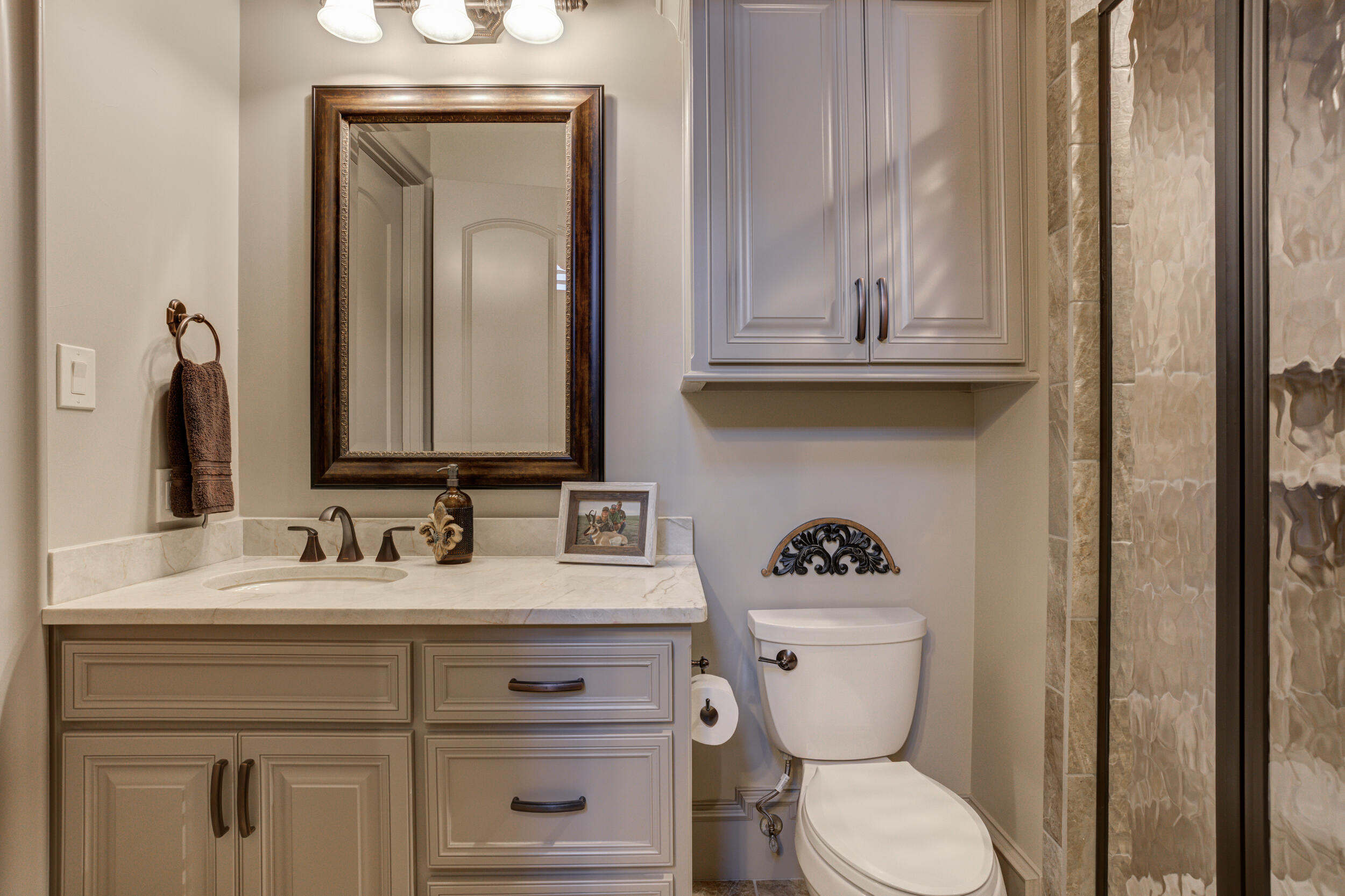 4815 119th Street Lubbock, TX 79424 - Photo 44 of 74 a bathroom with a toilet a sink a vanity and mirror