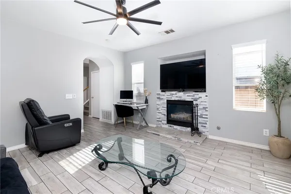 a living room with furniture a flat screen tv and a fireplace