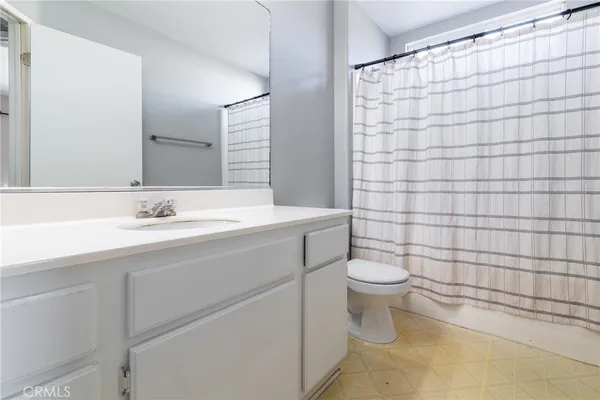a bathroom with a sink a toilet and shower curtain