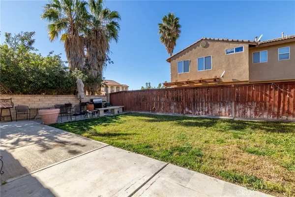 a backyard of a house with table and chairs