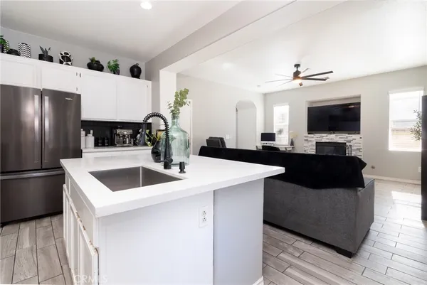 a kitchen with a refrigerator sink and white cabinets
