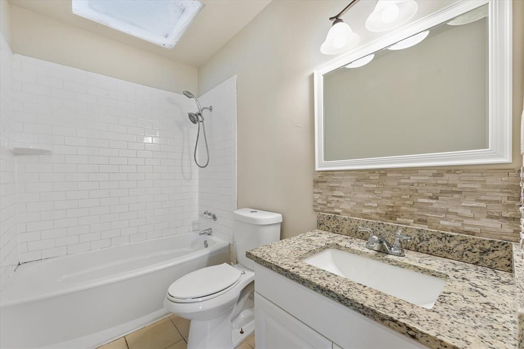 304 East Stone Road Wylie, TX 75098 - Photo 9 of 19 a bathroom with a granite countertop sink a toilet a mirror and shower