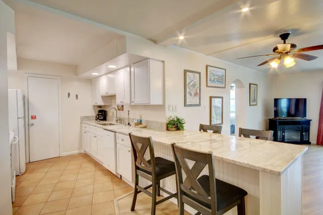 a kitchen with a table chairs refrigerator and cabinets