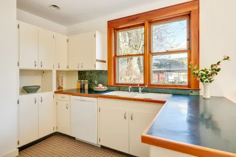 a kitchen with a sink window and cabinets