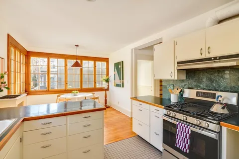 a large kitchen with stainless steel appliances granite countertop a stove and a sink