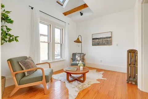 a living room with furniture a window and wooden floor