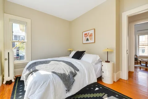 a bedroom with a bed and wooden floor