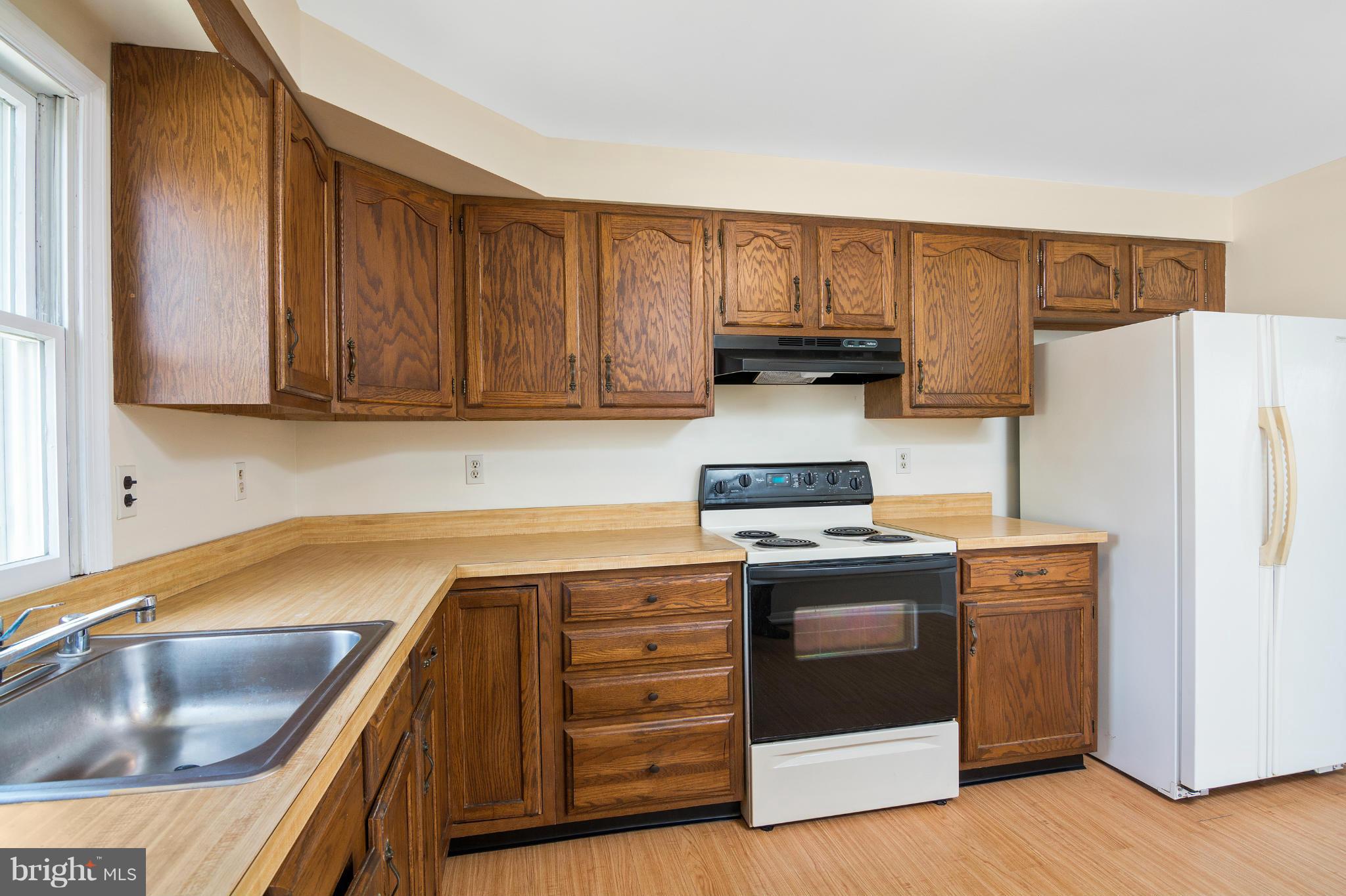 9005 Throgmorton Road Baltimore, MD 21234 - Photo 15 of 30 a kitchen with a sink a stove and refrigerator