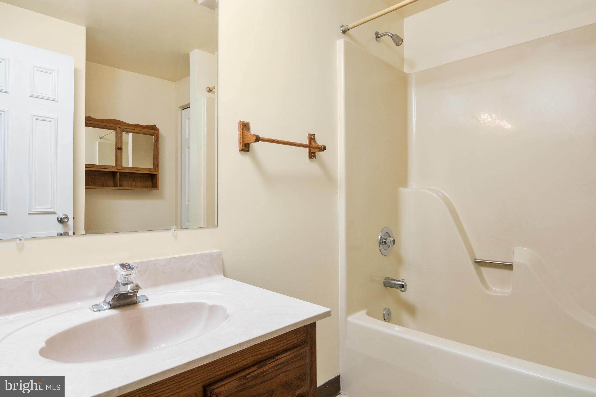 9005 Throgmorton Road Baltimore, MD 21234 - Photo 17 of 30 a bathroom with a sink a shower and a mirror