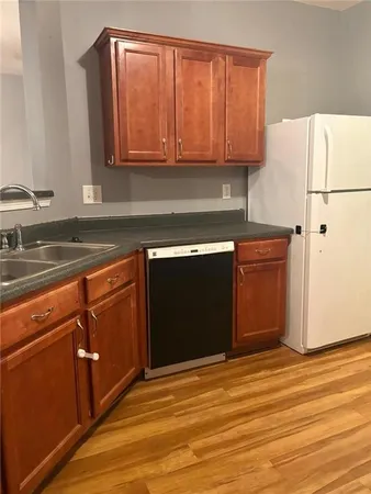 a kitchen with granite countertop cabinets sink and white appliances