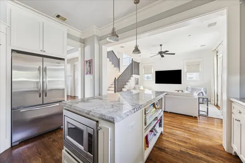 a kitchen with a stove and a flat screen tv