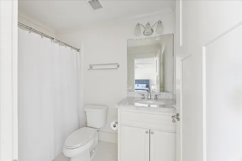 a bathroom with a toilet sink vanity and mirror