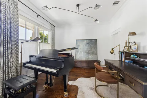 a living room with furniture and a piano