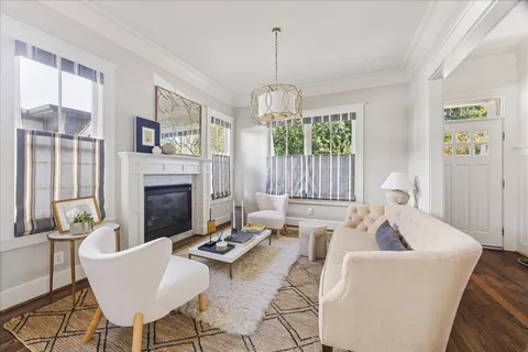 a living room with furniture a fireplace and a chandelier