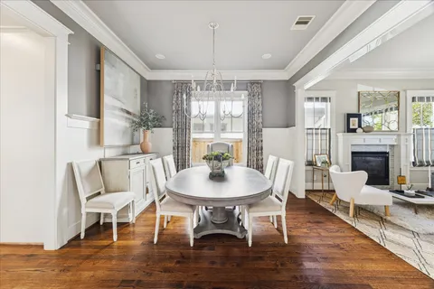 a dining room with furniture a chandelier and wooden floor