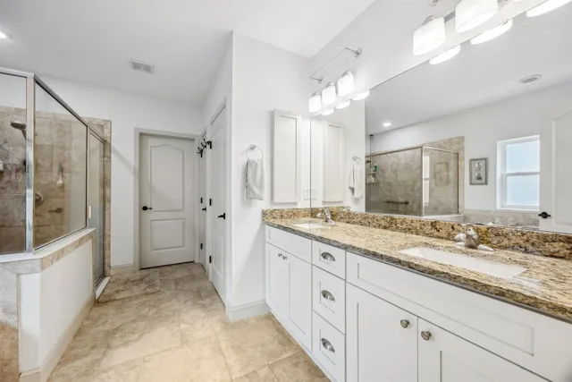 a bathroom with a granite countertop sink mirror and a shower