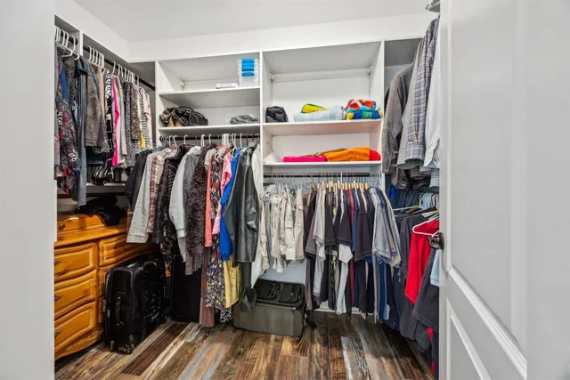 a view of walk in closet with clothes and shoes