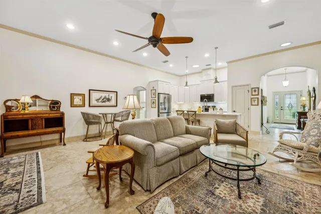 a living room with furniture kitchen view and a chandelier