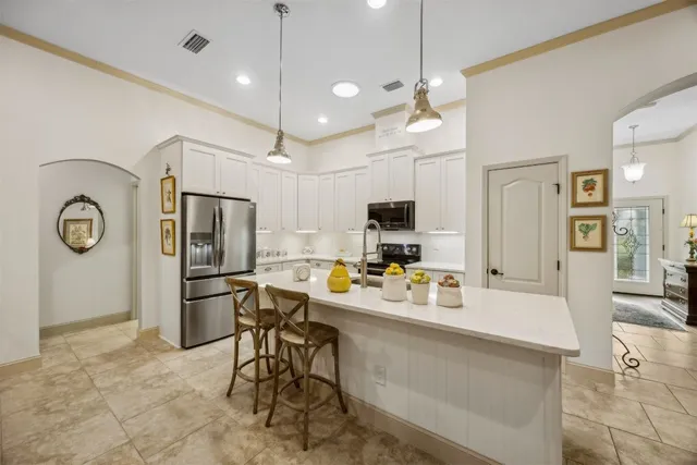 a kitchen with refrigerator and chairs