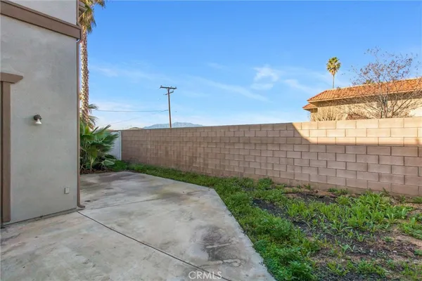 a view of a backyard with plants and wooden fence