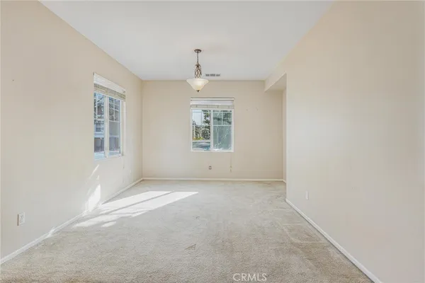 an empty room with closet and windows