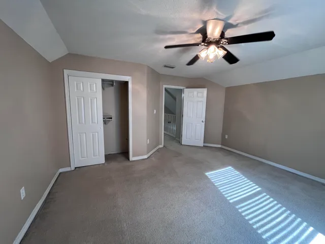 a view of an empty room with a ceiling fan